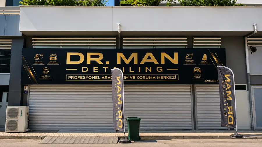 Dr. Man Detailing Bursa araç bakım merkezinde siyah zeminli gold baskılı vinil germe tabela